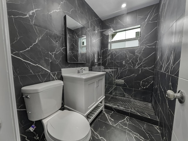 bathroom featuring tile walls, vanity, a tile shower, and toilet