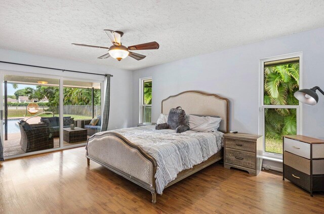 bedroom featuring a textured ceiling, a ceiling fan, wood finished floors, and visible vents