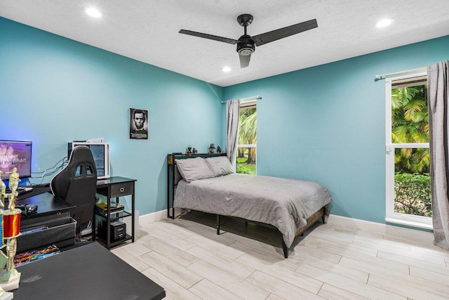 bedroom with baseboards, recessed lighting, wood finish floors, a textured ceiling, and ceiling fan