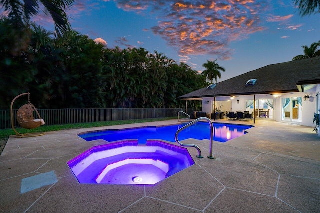 view of swimming pool featuring fence, a fenced in pool, a patio, and an in ground hot tub