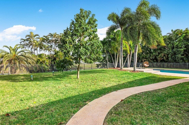 view of home's community featuring a lawn, a swimming pool, and fence