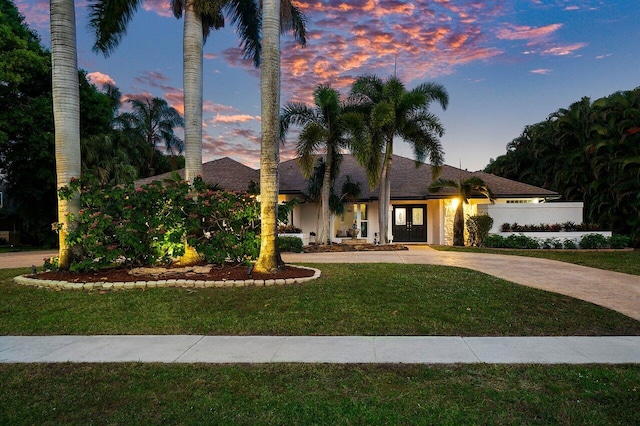 mediterranean / spanish-style house with a front lawn and driveway