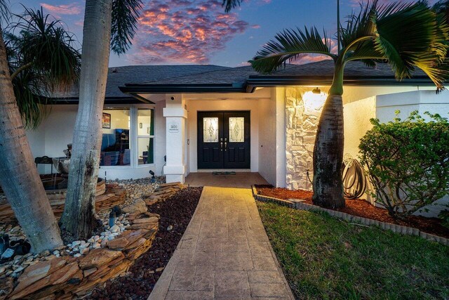 entryway featuring baseboards, light tile patterned flooring, french doors, and a textured ceiling