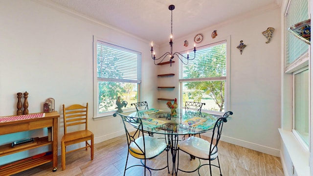 dining space featuring ornamental molding, plenty of natural light, an inviting chandelier, and light hardwood / wood-style flooring