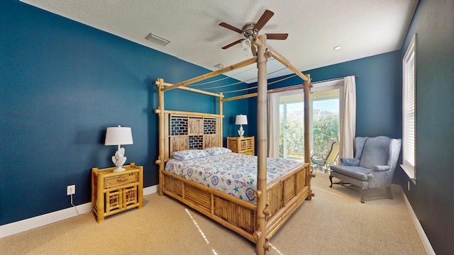 carpeted bedroom with ceiling fan and a textured ceiling