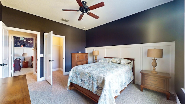 bedroom featuring a closet, a walk in closet, and ceiling fan