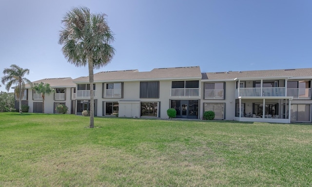 rear view of property featuring a lawn