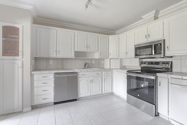 kitchen with white cabinetry, sink, backsplash, appliances with stainless steel finishes, and crown molding