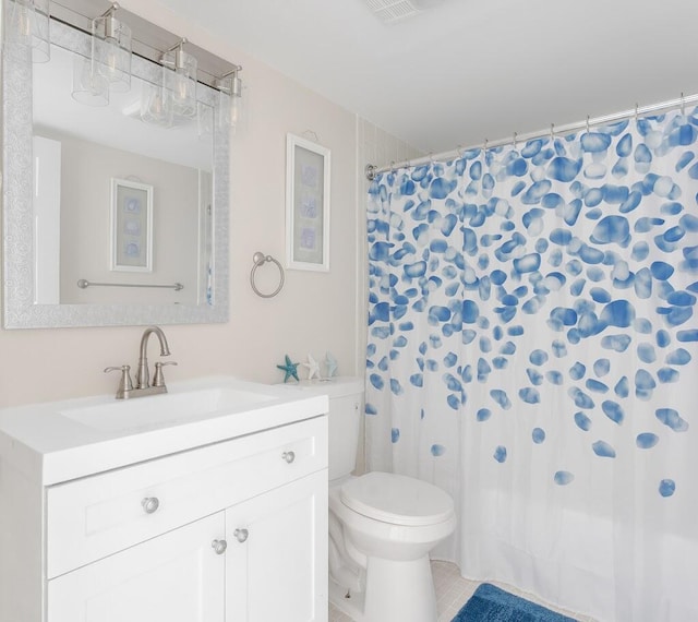 bathroom with vanity, tile patterned flooring, and toilet