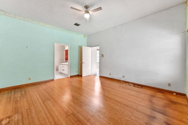 unfurnished bedroom with baseboards, light wood-style flooring, visible vents, and a textured ceiling