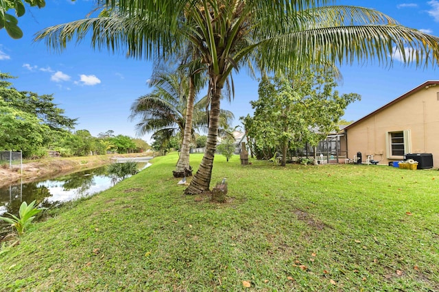 view of yard featuring a lanai and a water view