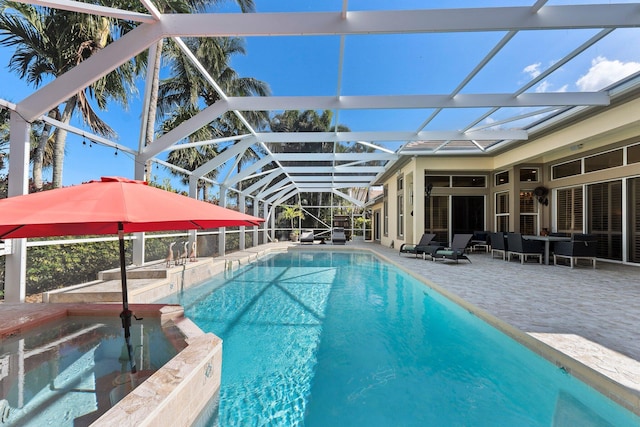 view of pool featuring a lanai, a patio area, and a pool with connected hot tub