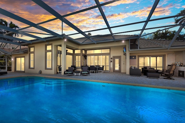 outdoor pool with a lanai, a patio area, and an outdoor living space