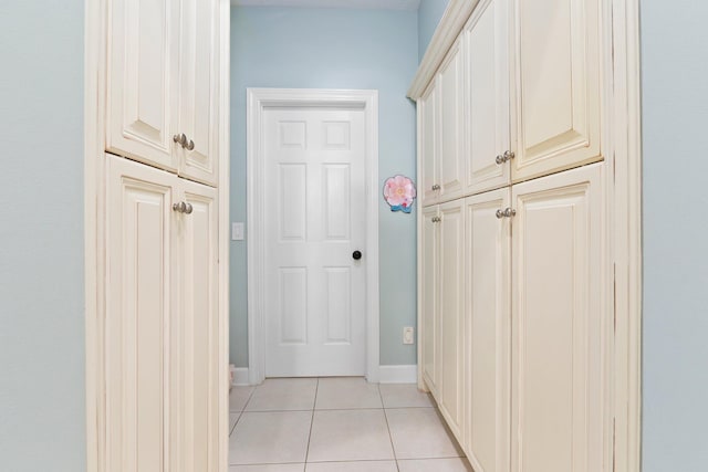 corridor featuring light tile patterned floors and baseboards