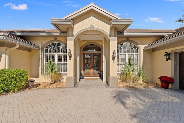 entrance to property featuring french doors and stucco siding