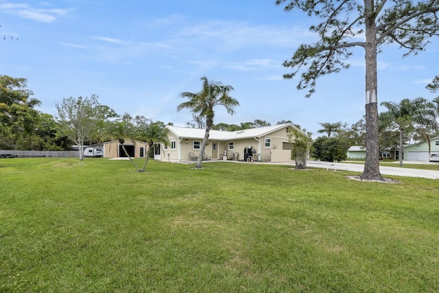 view of yard featuring driveway, an attached garage, and fence