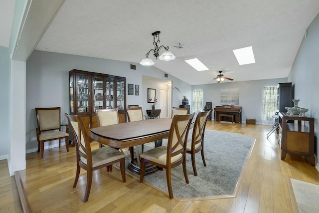 2103 SE Meadowbrook Rd, Stuart, FL 34997 - dining area featuring light wood-type flooring, lofted ceiling with skylight, baseboards, and visible vents