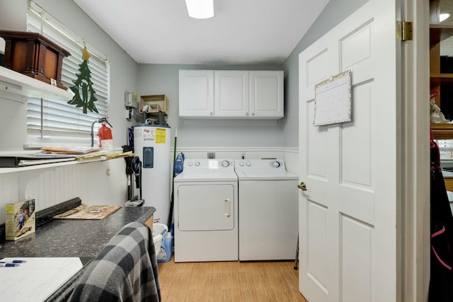 2103 SE Meadowbrook Rd, Stuart, FL 34997 - laundry area with water heater, washer and clothes dryer, cabinet space, and light wood-style floors