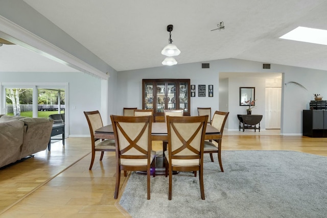2103 SE Meadowbrook Rd, Stuart, FL 34997 - dining space with lofted ceiling with skylight, light wood-style flooring, visible vents, and baseboards