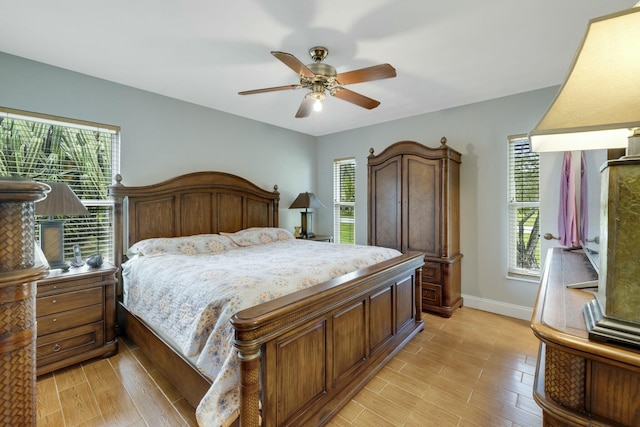 2103 SE Meadowbrook Rd, Stuart, FL 34997 - bedroom featuring a ceiling fan, light wood-type flooring, and baseboards