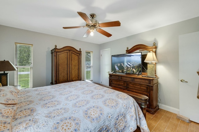 2103 SE Meadowbrook Rd, Stuart, FL 34997 - bedroom with light wood-style floors, ceiling fan, and baseboards