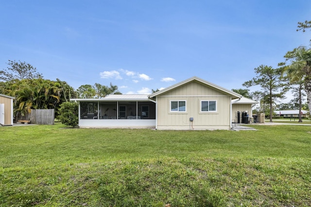 2103 SE Meadowbrook Rd, Stuart, FL 34997 - back of house featuring a sunroom, fence, and a yard
