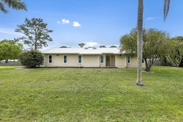 2103 SE Meadowbrook Rd, Stuart, FL 34997 - view of front of home with metal roof, fence, and a front lawn