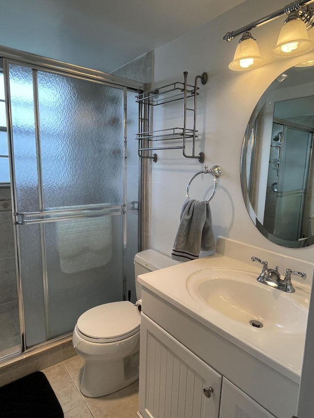 bathroom with tile patterned floors, a shower with shower door, toilet, and vanity