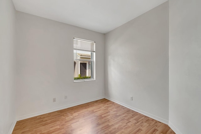 unfurnished room with baseboards and light wood-style floors