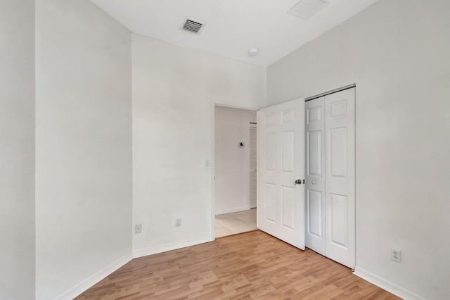 unfurnished bedroom featuring baseboards, visible vents, and light wood finished floors