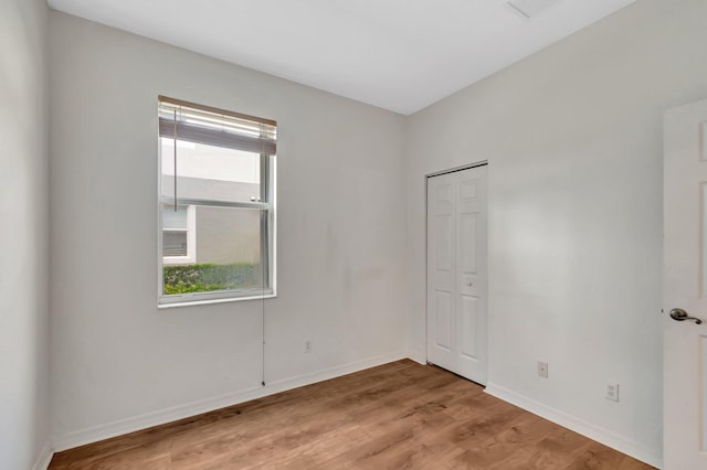 empty room featuring baseboards and light wood-type flooring