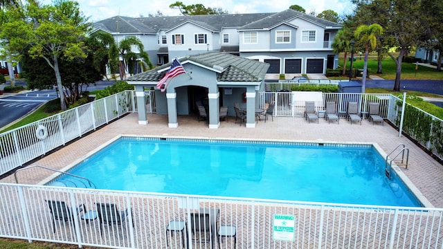 pool featuring fence, a residential view, and a patio area