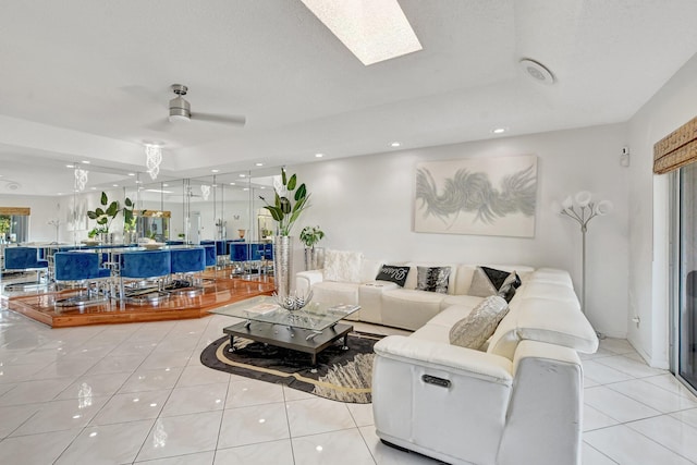 living area featuring light tile patterned floors, ceiling fan, a skylight, and recessed lighting