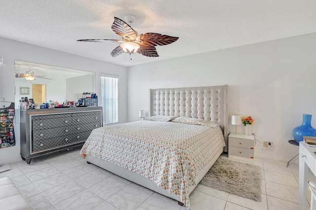 bedroom featuring a textured ceiling, ceiling fan, and light tile patterned flooring