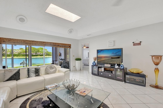 living area featuring a skylight and light tile patterned floors