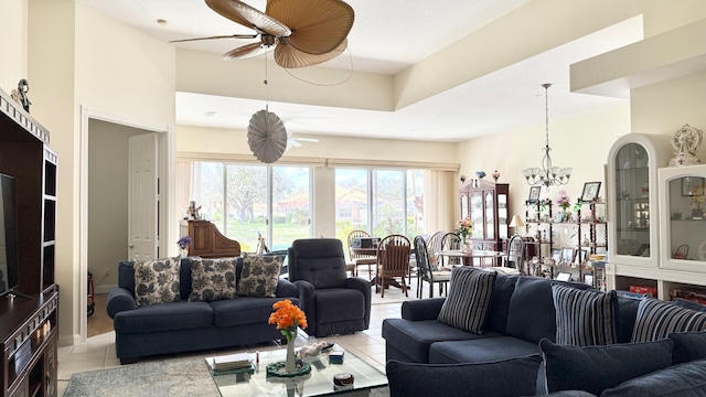 tiled living room with ceiling fan with notable chandelier