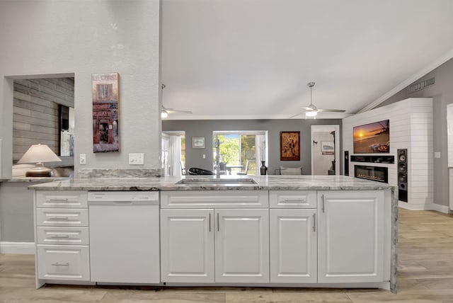 kitchen featuring dishwasher, a large fireplace, white cabinetry, and a ceiling fan