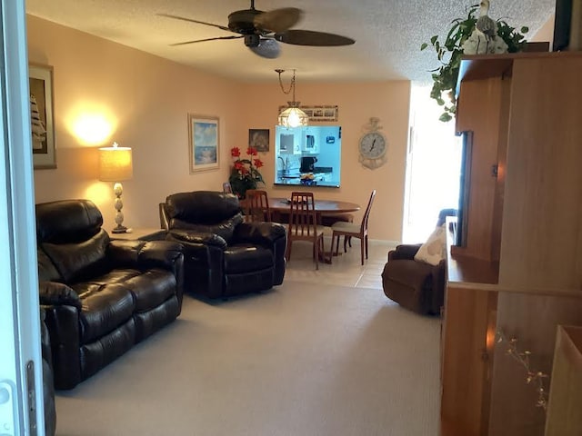 living room featuring ceiling fan and a textured ceiling