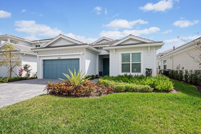 view of front of property with a front lawn, decorative driveway, and a garage