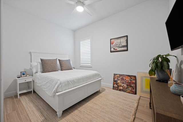 bedroom featuring light wood finished floors, baseboards, and a ceiling fan