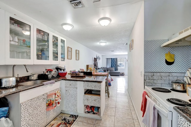 kitchen with white electric range, a textured ceiling, white cabinets, light tile patterned floors, and sink