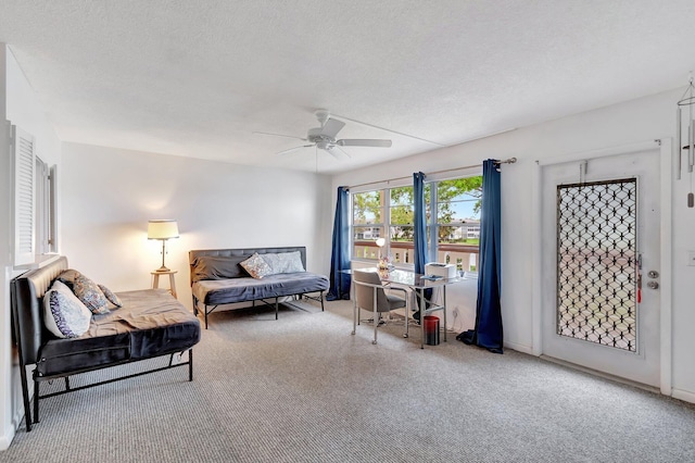 living area with carpet floors, ceiling fan, and a textured ceiling