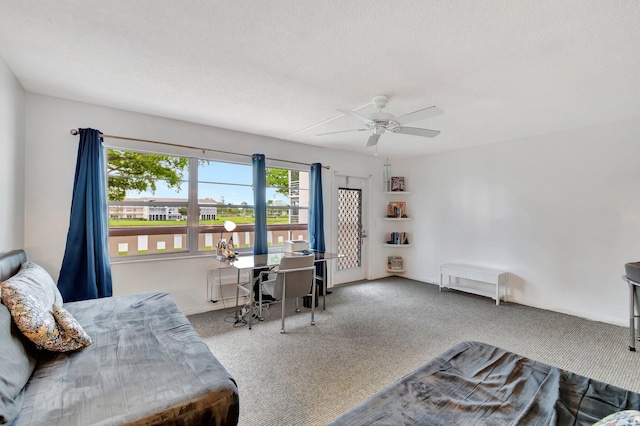 carpeted home office featuring ceiling fan