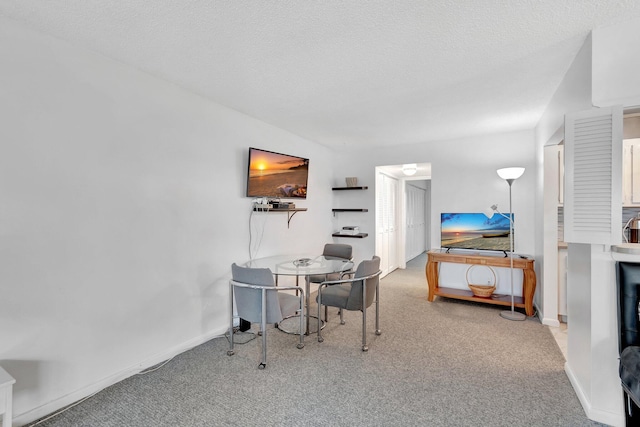 dining space featuring carpet flooring, a textured ceiling, and baseboards