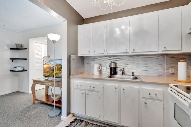 kitchen featuring white cabinetry, light countertops, a sink, and light colored carpet