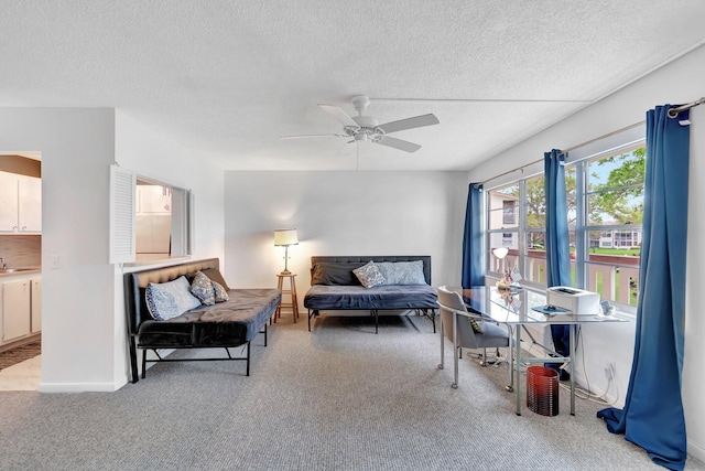 living area featuring ceiling fan, a textured ceiling, and light colored carpet