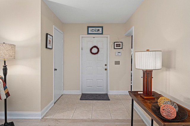 foyer entrance with light tile patterned floors and baseboards