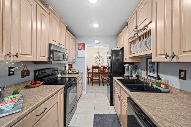 kitchen with black appliances, light brown cabinets, and light countertops