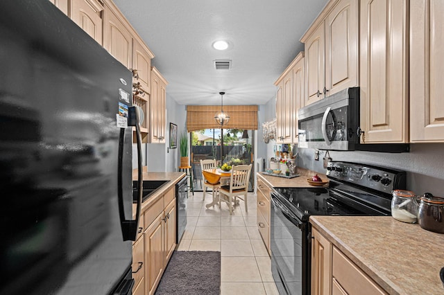 kitchen featuring light tile patterned floors, visible vents, hanging light fixtures, light countertops, and black appliances