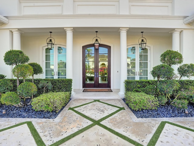 entrance to property with french doors, a wall unit AC, and stucco siding